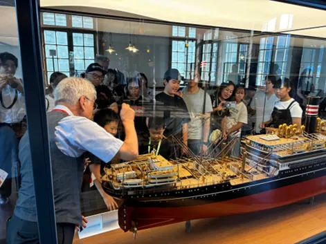 Children captivated by intricate ship models during the guided tour.