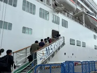 「飛鳥II」の船内に乗り込む参加者たち